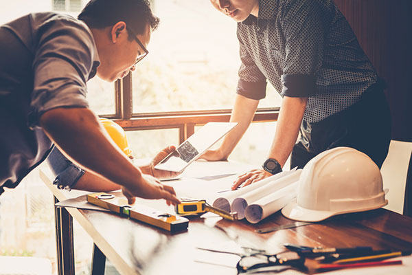 a construction manager and a general contractor looking at a construction blueprint
